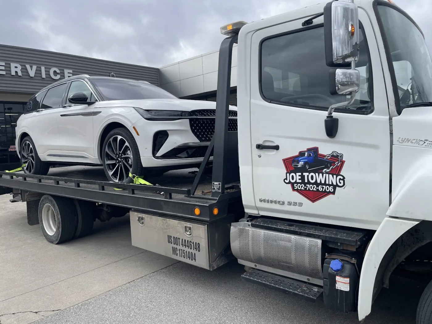 Joe Towing truck door with the company logo and the number 502-702-6706.